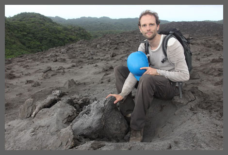 Richard sitting by volcanic bomb crater on Yasur volcano