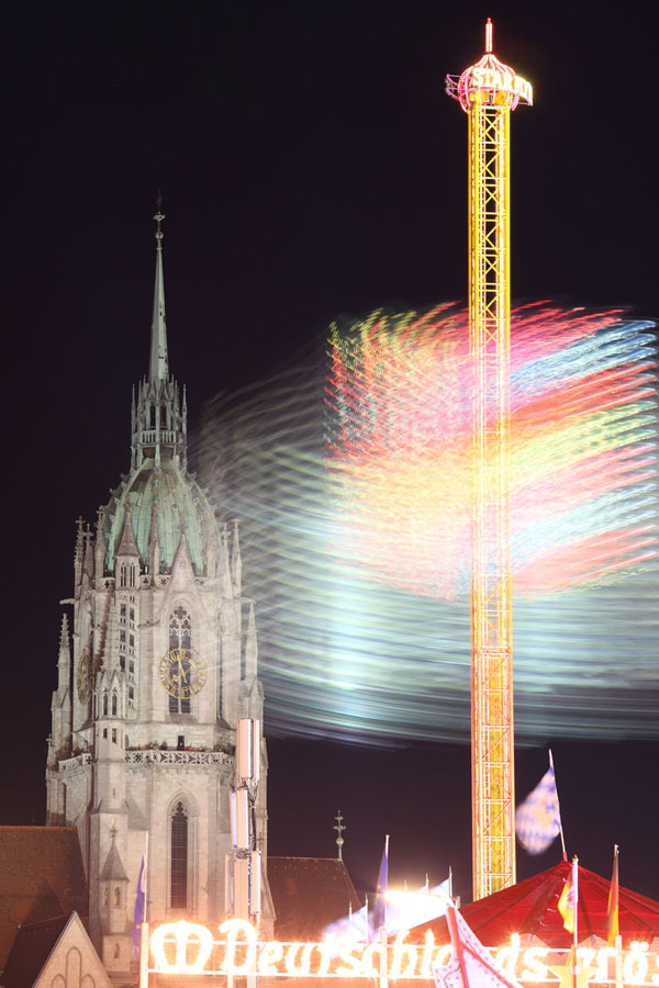 Oktoberfest Munich, 2011, Starflyer ascending chain carousel with St Paul church behind