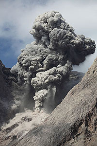 Explosive eruption producing dense ash cloud and volcanic bombs, Batu Tara volcano, Indonesia, portrait orientation