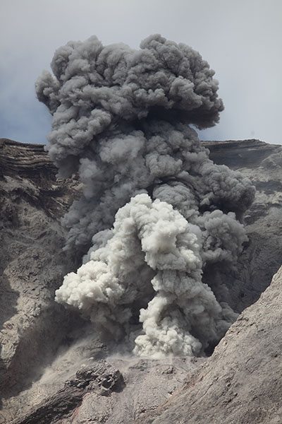 Ash cloud with white and grey sections following strombolian style eruption of Batu Tara volcano