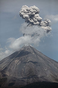 Ash cloud following explosive eruption of Colima volcano behind clouds