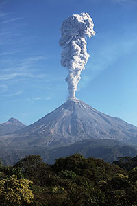 Ash cloud following explosive eruption of Colima volcano rising above surrounding lanbdscape