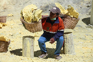 Kawah Ijen volcano, Solfatara, Sulfur Mine, Sulphur, Worker lifting baskets with sulfur