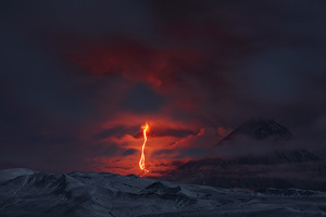 Nighttime view of Eruption of Kliuchevskoi volcano which is partially shrouded in cloud