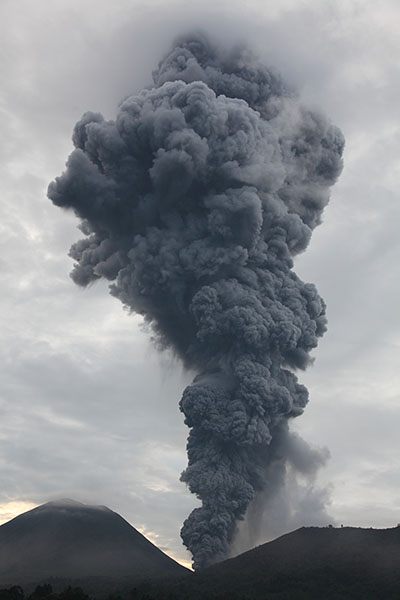 Dark grey ash cloud rising from Tompaluan Crater of Lokon-Empung Volcanic complex following vulcanian eruption
