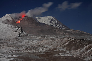 Glowing rockfall from lava dome of Shiveluch volcano, Kamchatka. Valley floor with warm deposits in foreground