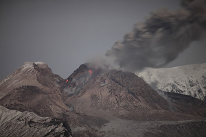 Nighttime view of lava dome of Shiveluch volcano venting ash