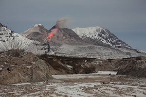 Glowing rockfall from lava dome of Shiveluch volcano, Kamchatka. Partially filled erosion gulley in foreground