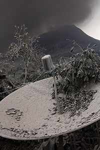 Satellite dish covered by ash and vegetation near Sinabung volcano
